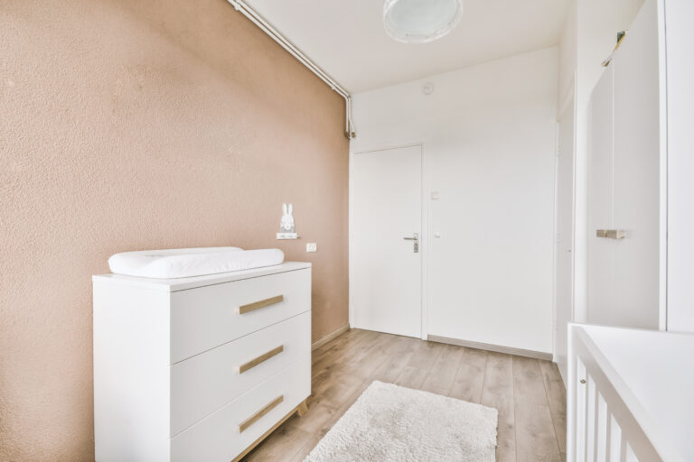 Minimalist interior design of small bedroom with soft bed placed in corner and wooden wardrobe and shelves with lamp illumination